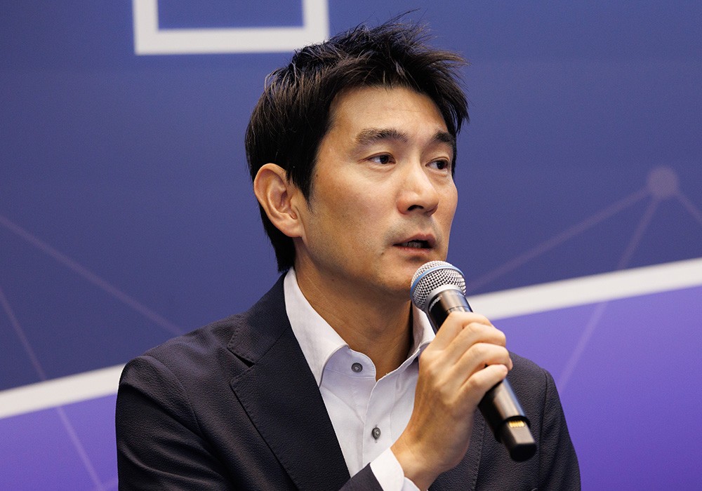 マイクをもって話す藤原氏