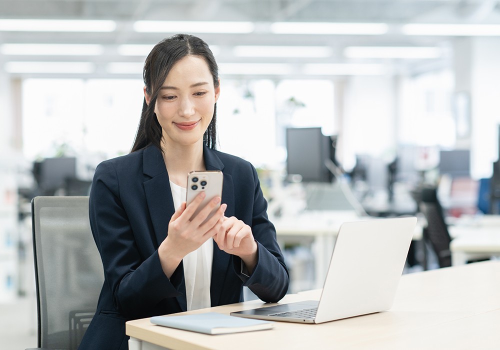 スマホで固定電話からの着信を取るビジネスパーソン