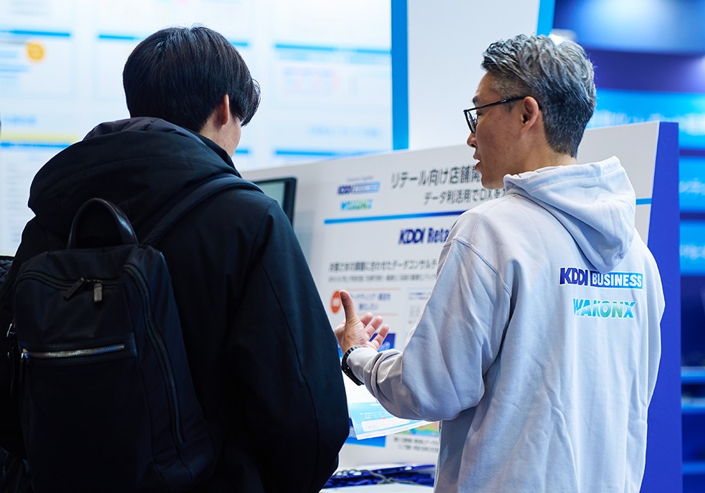 「KDDI Retail Data Consulting」ブースの説明員と来場者