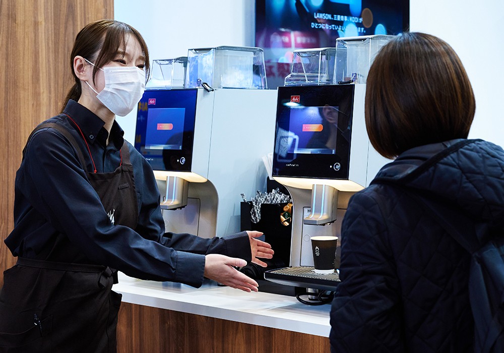 「MACHI café」ブースの説明員と来場者