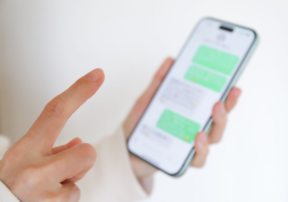 オフィスでシャドーITとしてスマホでチャットを利用するビジネスパーソン