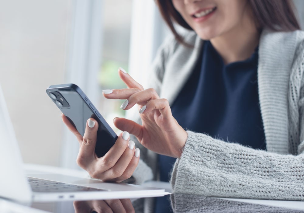 オフィスにてスマホでチャットを利用するビジネスパーソン