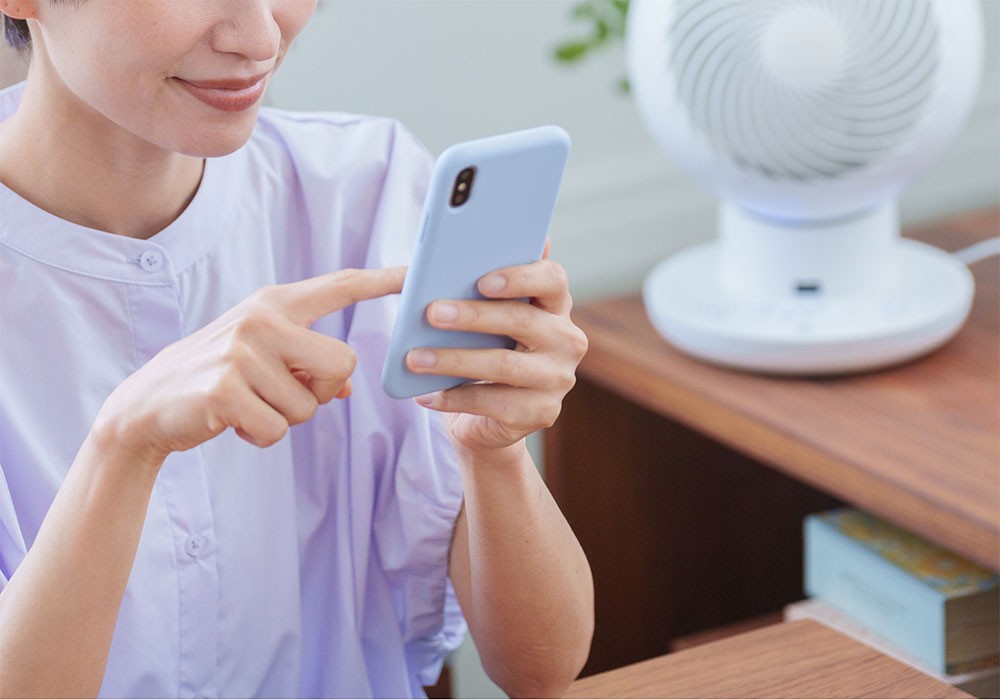 スマホに扇風機の風を当てて熱を冷ますイメージ画像