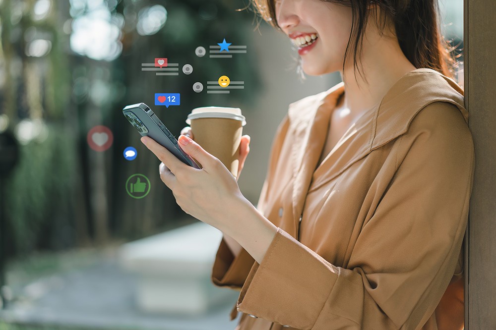 スマートフォンでSNSをチェックする女性。